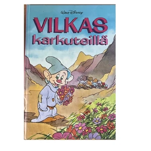 Vilkas karkuteillä - En färgglad bok från Walt Disney med titeln 'Vilkas karkuteillä'. Omslaget visar en tecknad figur i en blomstrande dal med berg i bakgrunden. Perfekt för Disney-fans och samlare av klassiska berättelser.