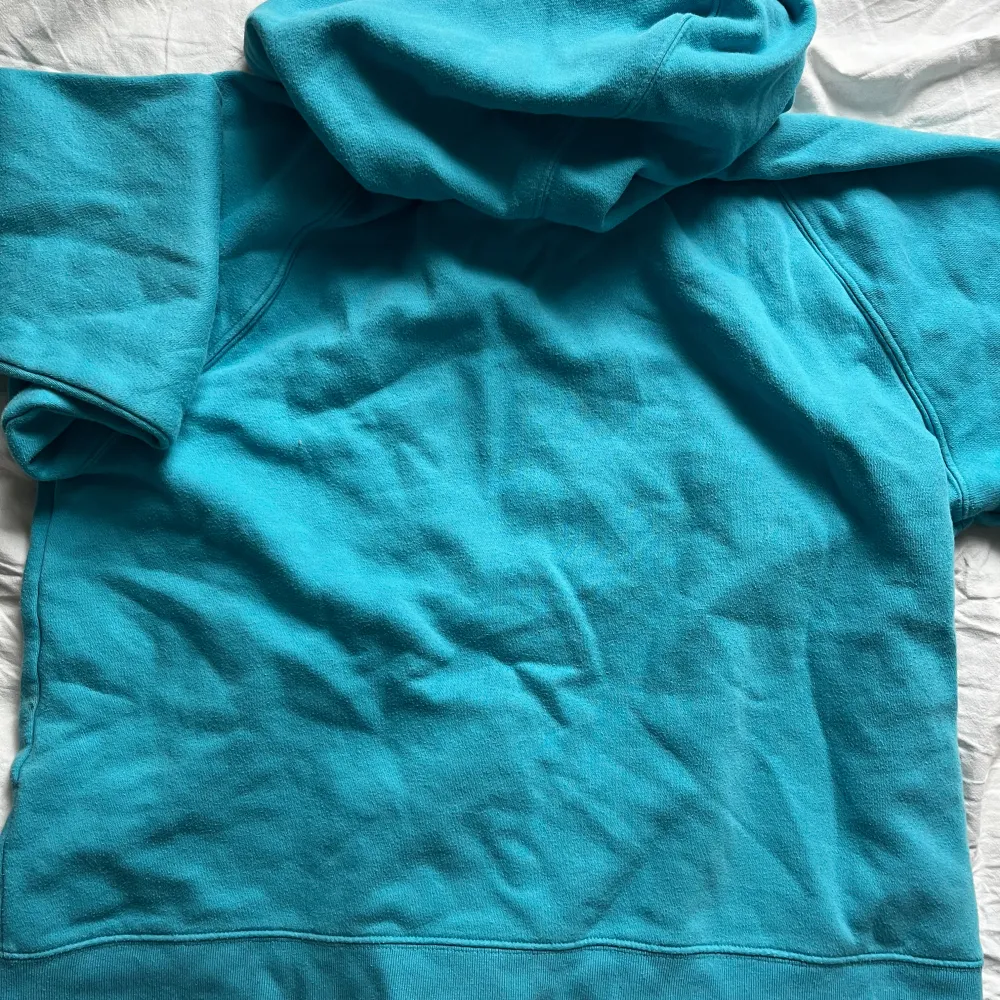 Säljer en snygg turkos hoodie från GAP med dragkedja och stor logga på framsidan. Perfekt för en avslappnad stil. Den har en mysig huva och långa ärmar.. Tröjor & Koftor.