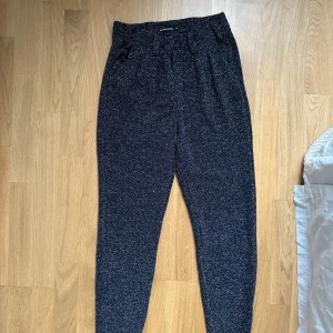 Svarta glittriga byxor från Rut&Circle - Snygga svarta byxor från Rut&Circle i storlek XS. Så sköna - känns som tights! Byxorna har en glittrig yta - perfekt till nyår! Slits längst ner vid anklarna. Passar mig som är 173 cm lång. Köparen står för frakt ✨