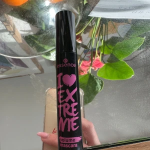 Essence I Love Extreme Volume Mascara - Essence I Love Extreme Volume Mascara i svart med en stor borste för maximal volym. Den har en svart tub med rosa text och är perfekt för att ge fransarna en dramatisk look. 