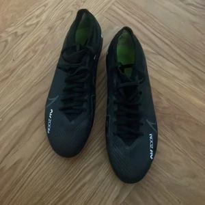 Svarta Nike fotbollsskor - Säljer ett par svarta Nike Mercurial fotbollsskor i bra skick. Använda endast ett fåtal ggr. Köpta på Unisport för 1800 kr. 