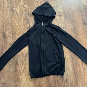 Träningströja med zip och luva - Svart träningströja med zip och luva. 