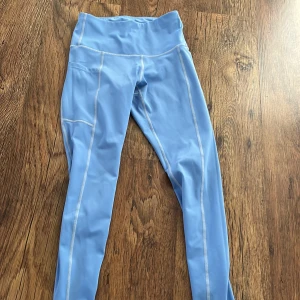 Blåa träningstights  - Blåa träningstights med ficka på benet. Har även resor i midjan. 