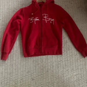 Röd huvtröja från Björn Borg - Säljer en snygg röd huvtröja från Björn Borg i storlek L barnstorlek så cirka xs. Tröjan har en dragkedja framtill och är långärmad med en bekväm passform. Perfekt för höst och vår! Den är i bra skick och redo för nya äventyr. 🧢