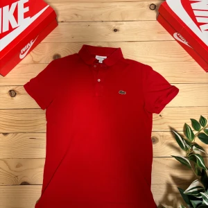 Röd Lacoste piké - En fin röd Lacoste piké med inga fläckar eller hål den är perfekt som jul tröja eller när våren kommer tillbaka. Storlek XS-S och är i 9/10 skick. Skriv om du har några frågor!