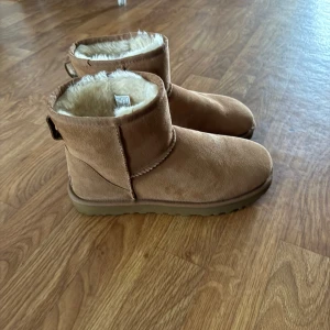 Uggs i storlek 40 - Ett par Uggs som är nyköpta har både kvitto och lådan kvar, de har fläckar bak på skon för mina jeans har färgat av sig ska försöka få bort de! Köpta för 2299kr 