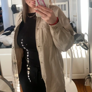 Beige overshirt - Säljer en beige overshirt i normal passform. Perfekt för lager-på-lager under hösten eller våren. Den har långa ärmar och knappar framtill. Superbekväm och lätt att matcha med olika outfits!