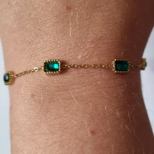 Armband 18k guldplätering  - Armband I 18k guldplätering med gröna stenar.  Detta armband är fotograferat med mitt personliga, på sista bild är det ni får alltså i oöppnad förpackning.   Rostfritt stål + 18k guldplätering 