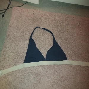 Marinblå o vit bikiniöverdel från Stadium - Säljer en stilren marinblå bikiniöverdel från Stadium i storlek S. Den har en enkel design med justerbara band och en bekväm passform. Perfekt för sommarens alla badäventyr! 🏖️