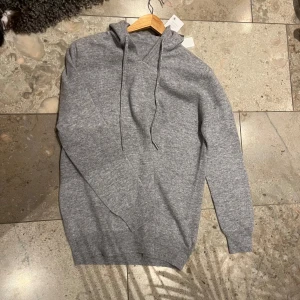 Grå merinoull hoodie från VIELLAS - Säljer en snygg och bekväm grå hoodie från VIELLAS. Ny pris är 899. Den är i nytt skick med etiketter kvar. Perfekt för höst och vinter, med en mjuk känsla och justerbar huva. Passar till både vardag och mysiga hemmakvällar. Aldrig använd. Hör av er om ni har någr frågor😃