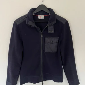 Moncler cardigan - Tjena! Nu är det tillslut dags att sälja min Moncler cardigan. Den är i relativt bra skick (7/10) men har förlorat fomen lite. Den är såklart äkta och jag har ett brev som konfermerar det vilket ni kan se vid den sista bilden. Jag tar även byten.