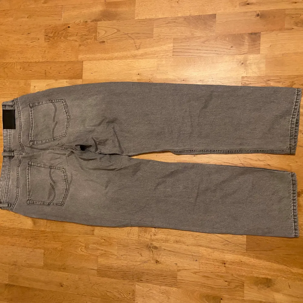 Säljer ett par grå jeans från Jack & Jones i storlek 170/15Y. De har en avslappnad passform och är perfekta för en casual look. Byxorna är i bra skick och passar både till vardags och lite mer avslappnade tillfällen. Perfekt för dig som gillar en bekväm stil!. Jeans & Byxor.