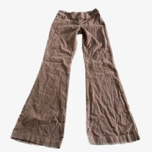 Rosa manchesterbyxor från H&M - Säljer ett par rosa manchesterbyxor från H&M i storlek 34. Byxorna har en bootcut-stil, perfekt för höst och vinter. De är lågmidjade och gjorda i mjukt manchestertyg, vilket ger en retro och stilren look. Perfekta för både vardag och fest!