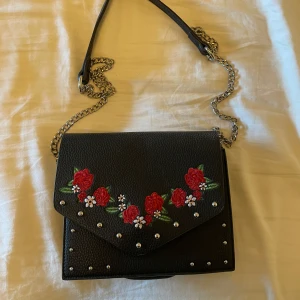 Svart väska  - Svart väska från Pull&bear med röda blommor 