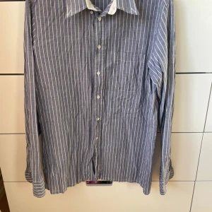 Blå och vit randig skjorta från Stenströms - Säljer en stilren blå och vit randig skjorta från Stenströms. Skjortan har långa ärmar och knappar framtill. Perfekt för både vardag och festliga tillfällen. Den är i perfekt skick!