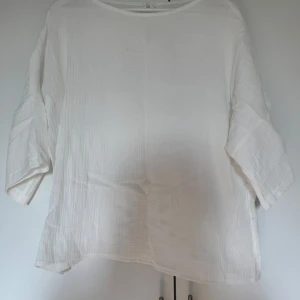 Vit löst sittande blus - Säljer en vit blus i ett löst sittande snitt. Den har trekvartsärmar och är perfekt för en avslappnad stil. Materialet känns lätt och luftigt, vilket gör den idealisk för vår och sommar.