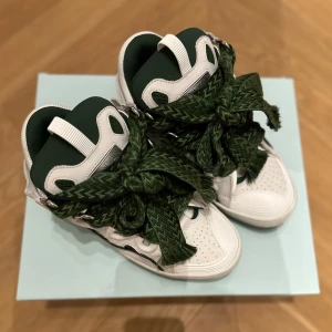 Lanvin Curb sneakers - Säljer dessa riktigt feta och eftertraktade Lanvin Curb sneakers. De är köpta på Lanvin butiken i Monaco. Skorna säljs på Farfetch för runt 14,000kr. De är i storlek 42. Allt medföljer, även kvitto finns. Skorna är oanvända. Pris kan diskuteras