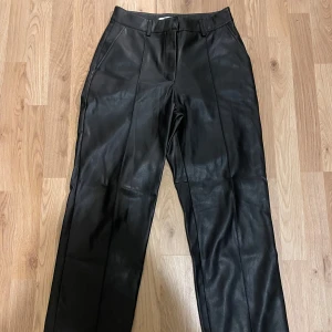 Svarta skinnbyxor från NA-KD - Snygga svarta skinnbyxor från NA-KD som är mid-waist och raka ben! Dom är väldigt sköna och passar perfekt nu under vintern🤍Storlek 36