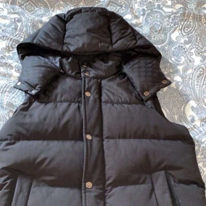 Gucci GG Väst - Gucci väst med avtagbar luva och knappar framtill. Västen är perfekt för kyligare väder!