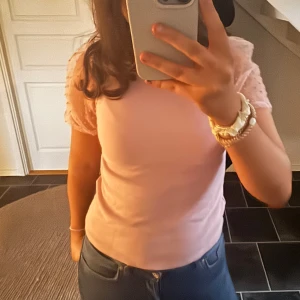 Rosa topp från Lindex - Söt rosa topp från Lindex🌸 med korta ärmar i transparent tyg med prickigt mönster. Perfekt för en somrig look.💝🎀