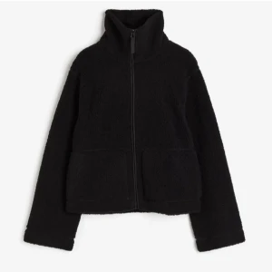 Svart teddyjacka H&M - Mysig svart teddyjacka med hög krage och dragkedja framtill. Perfekt för kyliga dagar med sin mjuka och varma känsla. Jackan har långa ärmar och två stora fickor framtill.🩷Den är slutsåld på HM hemsida🩷Skriv till mig gällande mer frågor!! PRISET KAN DISKUTERAS!