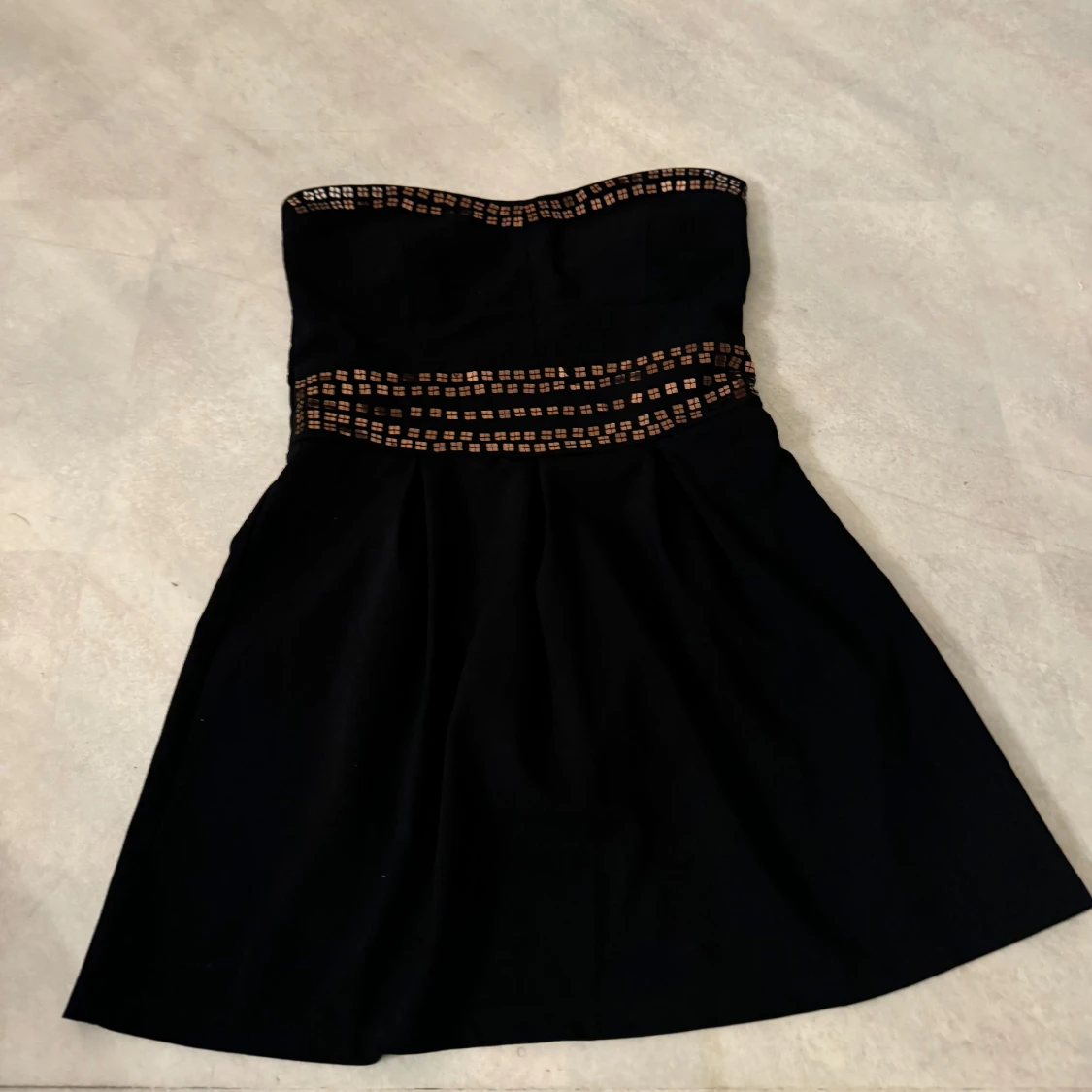 Svart axelbandslös klänning med detaljer