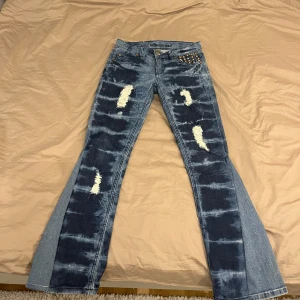 Blå bootcut jeans med nitar - Snygga blå bootcut jeans med slitna detaljer och coola nitar vid fickorna. Jeansen har en unik tvättad look och är perfekta för en trendig stil. De har en lågmidjad passform och klassiska femficksdesign. Skriv om ni har frågor!💓