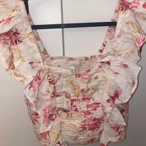 Blommig topp med volanger - Super fin och söt topp från hm med volanger, knappt använd och inga defekter💓💓💓💓