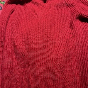 Röd stickad tröja - Säljer en mysig röd stickad tröja perfekt för kyliga dagar. Tröjan har en enkel design med långa ärmar och en varm känsla. Perfekt för att hålla sig varm och stilren.