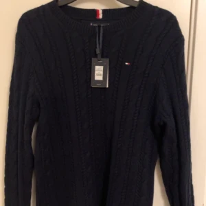 Mörkblå stickad tröja från Tommy Hilfiger - Helt ny kabbelstickad tröja från Tommy hilfiger i storlek s. Perfekt till kallare dagar pris inte hugget i sten🤝🤝