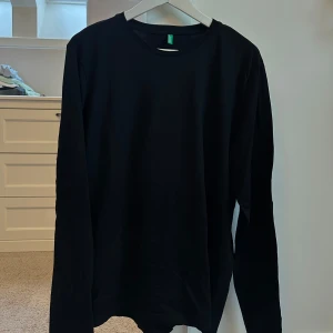 Svart långärmad tröja - Snygg och enkel svart långärmad tröja perfekt för alla tillfällen. Den har en klassisk rund hals och är tillverkad i ett mjukt material som ger en skön passform.