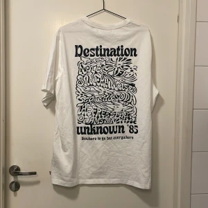 Vit t-shirt från Scotch & Soda - Säljer en vit t-shirt från Scotch & Soda med tryck på både fram- och baksida. Perfekt för en casual look. Köpte en för mycket så jag har ej använt den. Är i nyskick. 