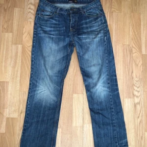  Smog Denim Pants  - Säljer ett par klassiska blå jeans från Smog i storlek 32. De har en straight passform och knappar i gylfen. Perfekta för en avslappnad stil.