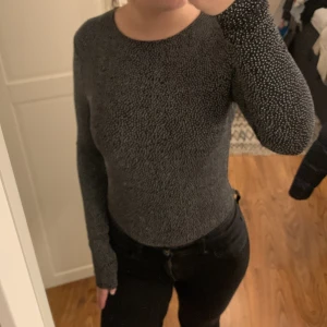 Svart vitprickig långärmad topp med öppen rygg från Gina Tricot - Snygg svart långärmad topp från Gina Tricot med vita prickar och en öppen rygg. Köparen betalar frakt!!!