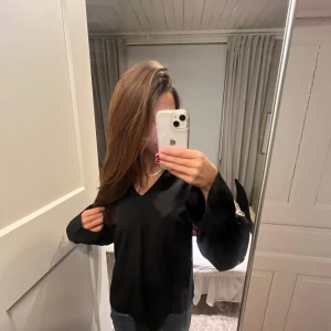 Svart långärmad blus  - Säljer en stilren svart långärmad tröja med v-ringning. Perfekt för en enkel och elegant look. Passar bra till både jeans och kjol. Skriv för mer bilder 