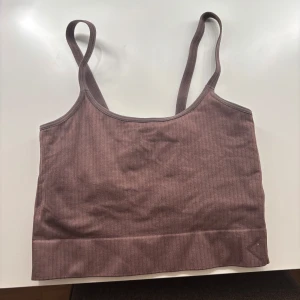 Brun ribbad linnetopp - Säljer en stilren brun ribbad linnetopp med smala axelband. Perfekt för en avslappnad look eller som basplagg i garderoben. Tränings topp!