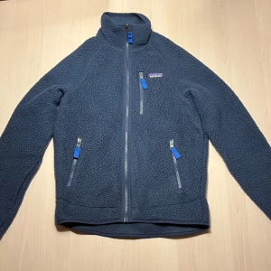Oanvänd Blå Patagonia fleecejacka - Säljer en helt ny och oanvänd Patagonia Retro Pile Jacket, då den var för liten för mig. Nypris: 1699kr. Slut i butik i hela Sverige i storleken XS. Kvitto finns och kontakta mig om funderingar!