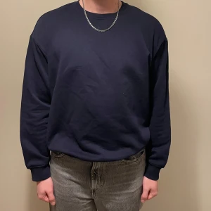 Mörkblå tröja från H&M - Säljer en mörkblå tröja från H&M i loose fit. Tröjan har långa ärmar och är perfekt för en avslappnad stil. Den är tillverkad i ett mjukt material som känns skönt mot huden. Nyskick. 