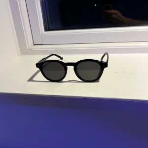 Svarta solglasögon från Chimi - Snygga svarta solglasögon från Chimi med rund form och mörka linser. Perfekta för en stilren look. Modell: 03 black. Skriv vid fråga eller fundering!👍