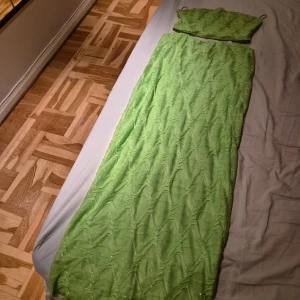 Kjol och topp från Gina Tricot - Snygg grön glittrig långkjol med tillhörande topp från Gina Tricot. Perfekt för sommarens festligheter. Klänningen har en elegant och enkel design som gör den lätt att styla.