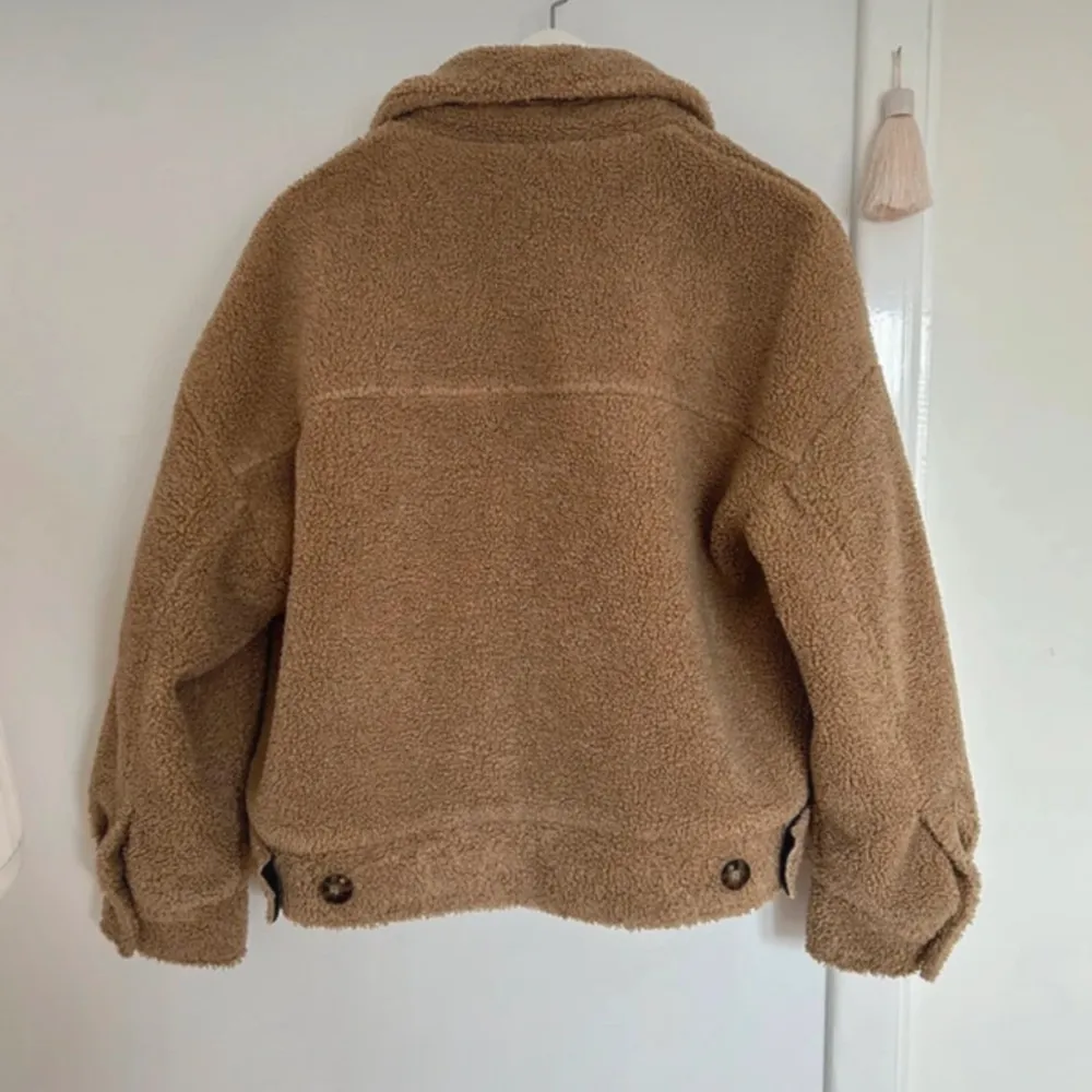 Mysig beige teddyjacka med knappar och två bröstfickor. Perfekt nu till vintern. . Takit.