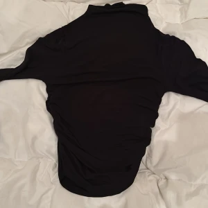 Svart polotröja från Gina Tricot - Säljer en stilren svart polotröja från Gina Tricot. Perfekt för kyligare dagar med sin höga krage och långa ärmar. Tröjan är i en mjuk och bekväm kvalitet.