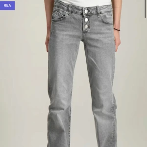 Gina jeans - Snygga grå jeans med låg midja med bootcut-stil.  Trendiga jeansen från Gina som inte säljs längre, säljer pga att dom inte kommer till användning. Dom är klippta nertill! 