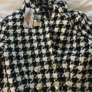 Svartvit rutig kavaj från Amisu - Snygg svartvit rutig kavaj från Amisu med guldknappar. Perfekt för dig som skaffat ny stil och vill ha lite mer old money vibes.☺️🫶🏻👼 Kavajen har en klassisk passform och är tillverkad i ett mjukt material.