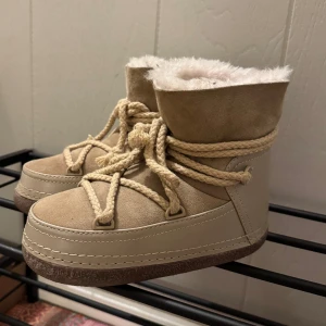 Beige boots från Inuikii - Säljer ett par snygga beige boots från Inuikii med fluffigt foder och grov snörning.  Väldigt sparsamt använda. Ett litet slitage på ena skon där bak ( se sista bilden ) men inget man tänker på. Storlek 36