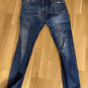 Blå Armani jeansbyxor herr - Säljer ett par klassiska blå jeans med en snygg tvätt. De har en normal passform och midwaist. Perfekta för en avslappnad stil.