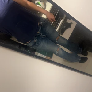 Blå jeans med broderade detaljer från Miss Me - Snygga blå jeans från Miss Me med unika broderade detaljer på bakfickorna. Jeansen har en bootcut passform och slitna detaljer som ger en cool look. Köpta för 1200kr säljer för att de är för stora för mig💕