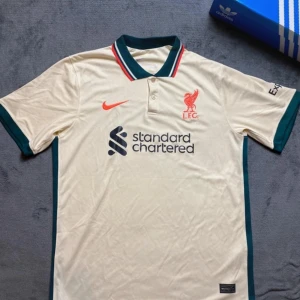 Liverpool tröja  - Hejsan säljer denna nästan aldrig använda fotbollströjan i strl L. Den är stilig och passar tills det mesta. Speciellt om du är liverpool supporter passar denna tröjan dig. Men även om du bara gillar att ha olika lags fotbollströjor! Tveka inte o höra av dig om mer frågor!