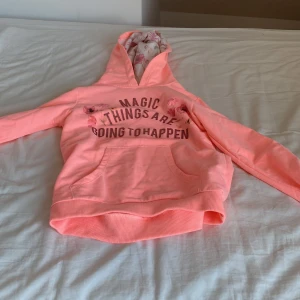 Rosa hoodie från Zara Girls - Säljer en söt rosa hoodie från Zara Girls med texten 'Magic Things Are Going to Happen' på framsidan. Hoodien har en mysig huva med blommigt foder och en praktisk magficka. Perfekt för en avslappnad stil.
