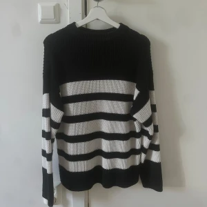 Svartvit randig stickad tröja - Säljer en stilren svartvit randig stickad tröja med långa ärmar. Perfekt för kyligare dagar och ger en klassisk look. Passar bra till både jeans och kjol. Den ör i storlek 146,152 från gina trico young